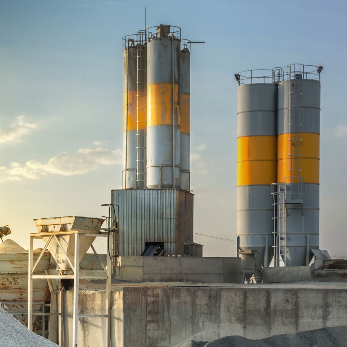 Industrial Facility with Silos and Raw Material Storage at Sunset