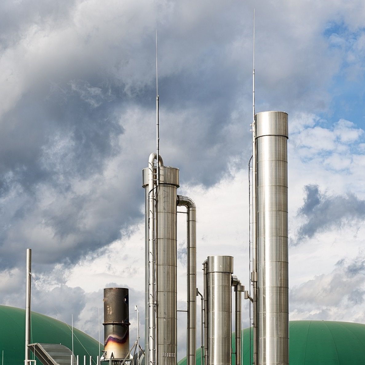 A modern biogas plant under the cloudscape of an approaching thunderstorm.