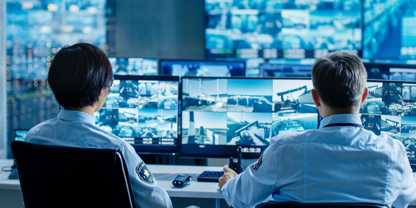 Security personnel monitoring building security on screens 