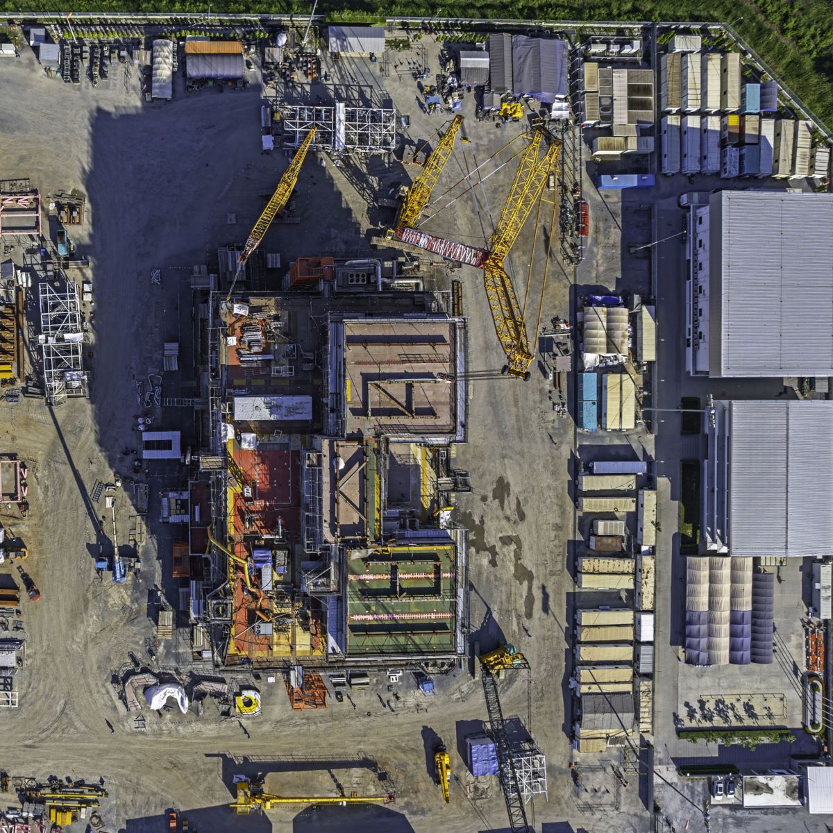 hon-aerial-heavy-construction-site-cranes-industrial-complex-1855567610.jpg