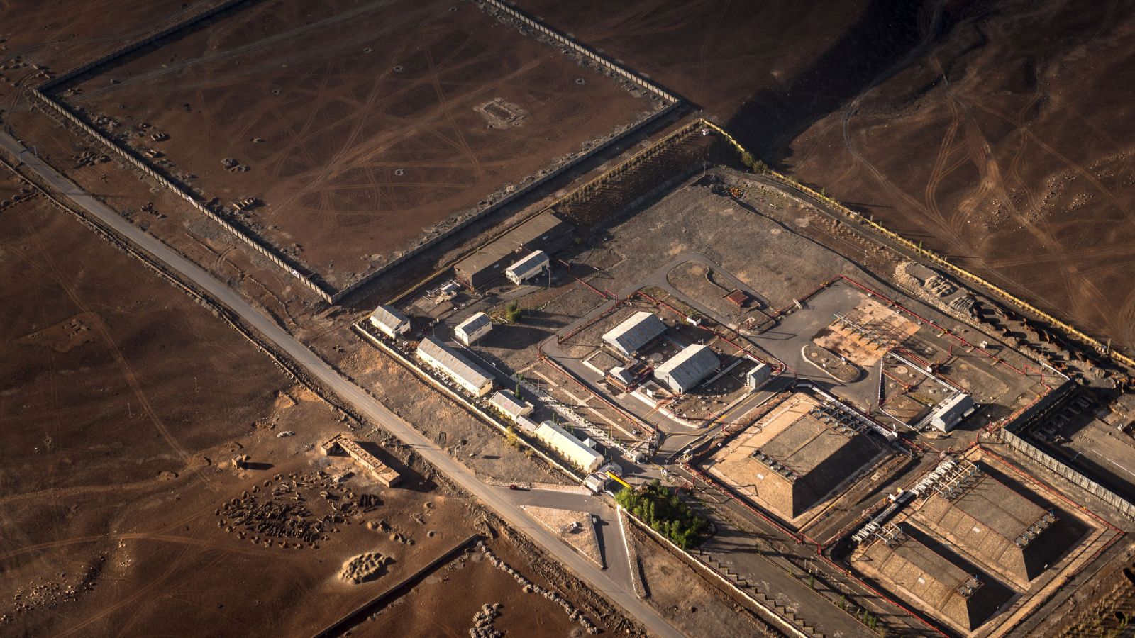 An aerial photograph showcasing an industrial complex surrounded by a barren landscape, highlighting its structures and layout.