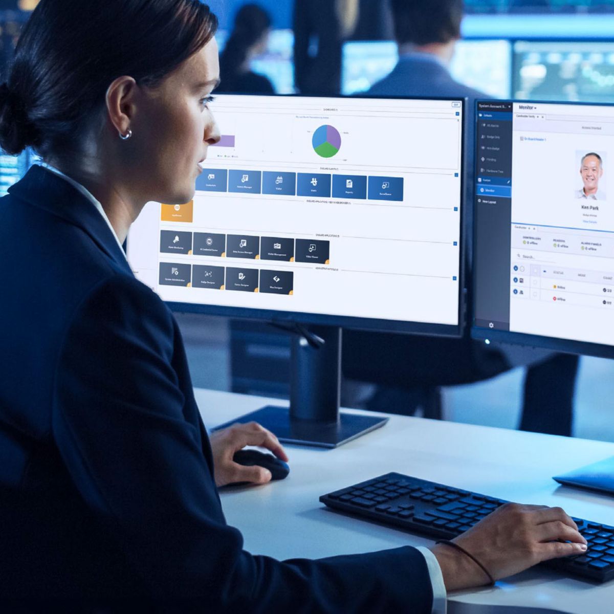 A security operations workstation displays real‑time dashboards and surveillance feeds across dual monitors in a modern control room.