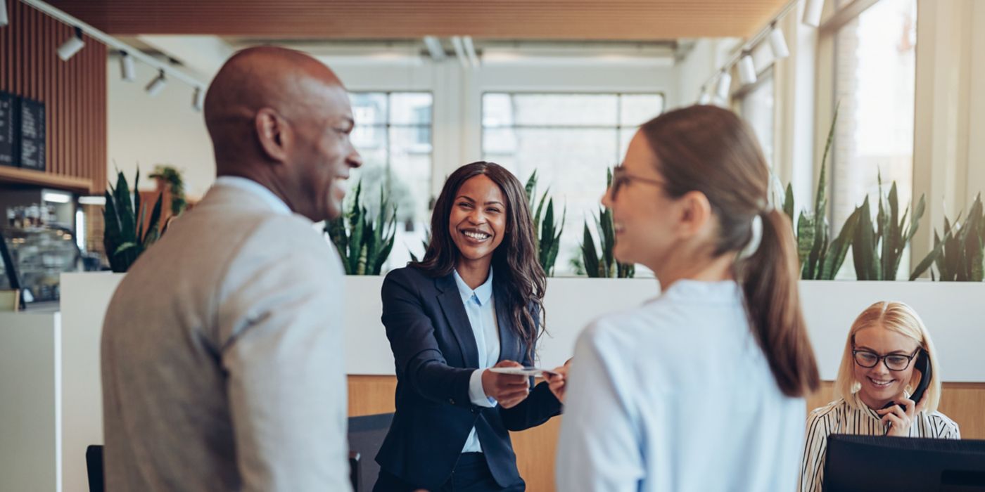 Four colleagues interact in bright, contemporary office work setting.