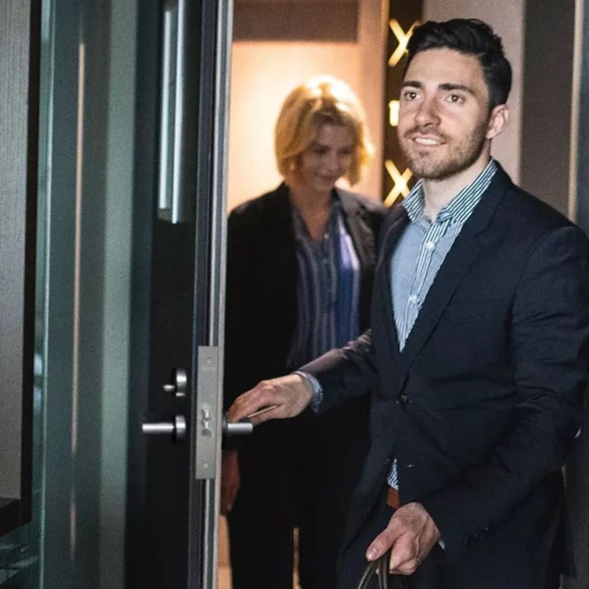 Man and woman entering a hotel room with bags