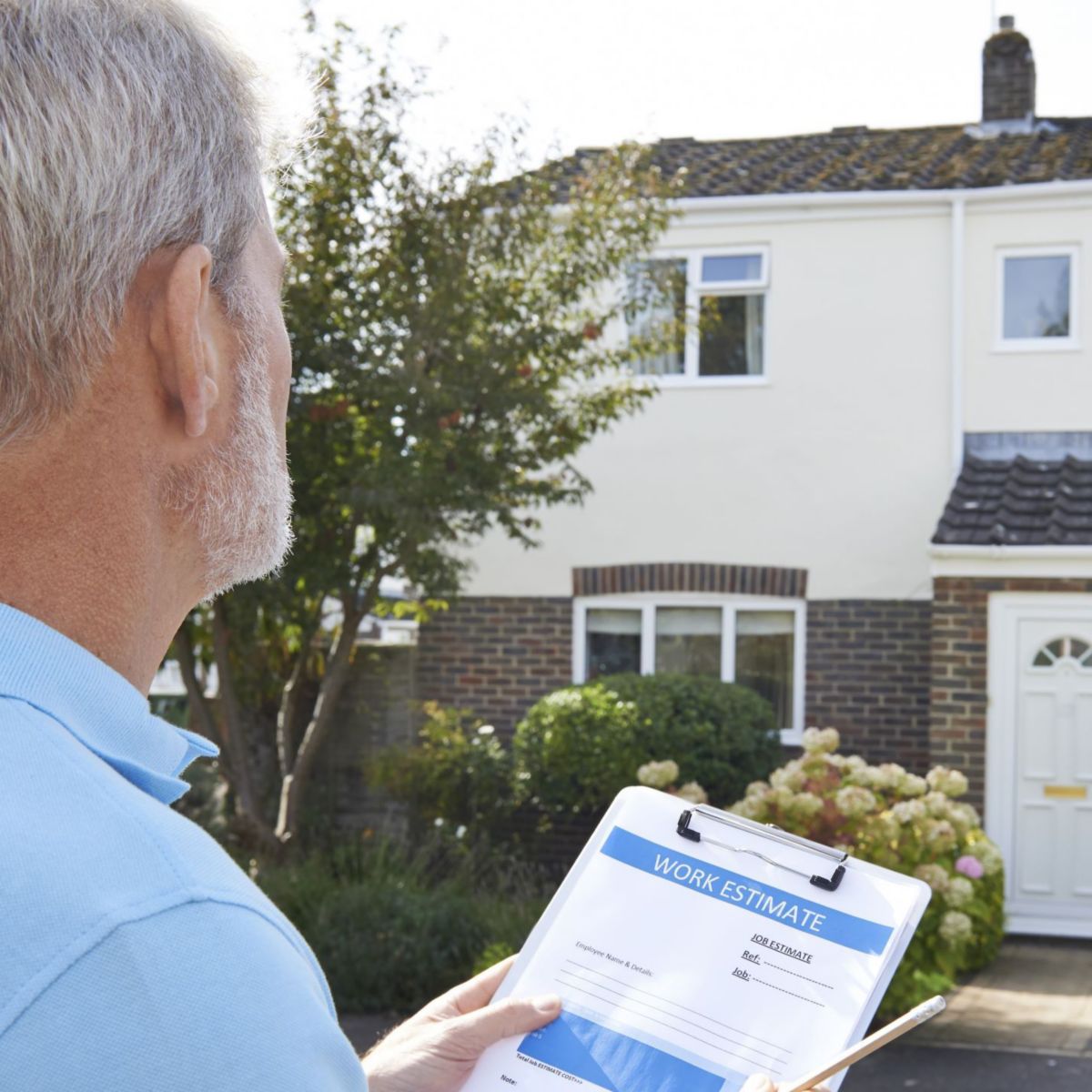 Male taking notes outside exterior of house