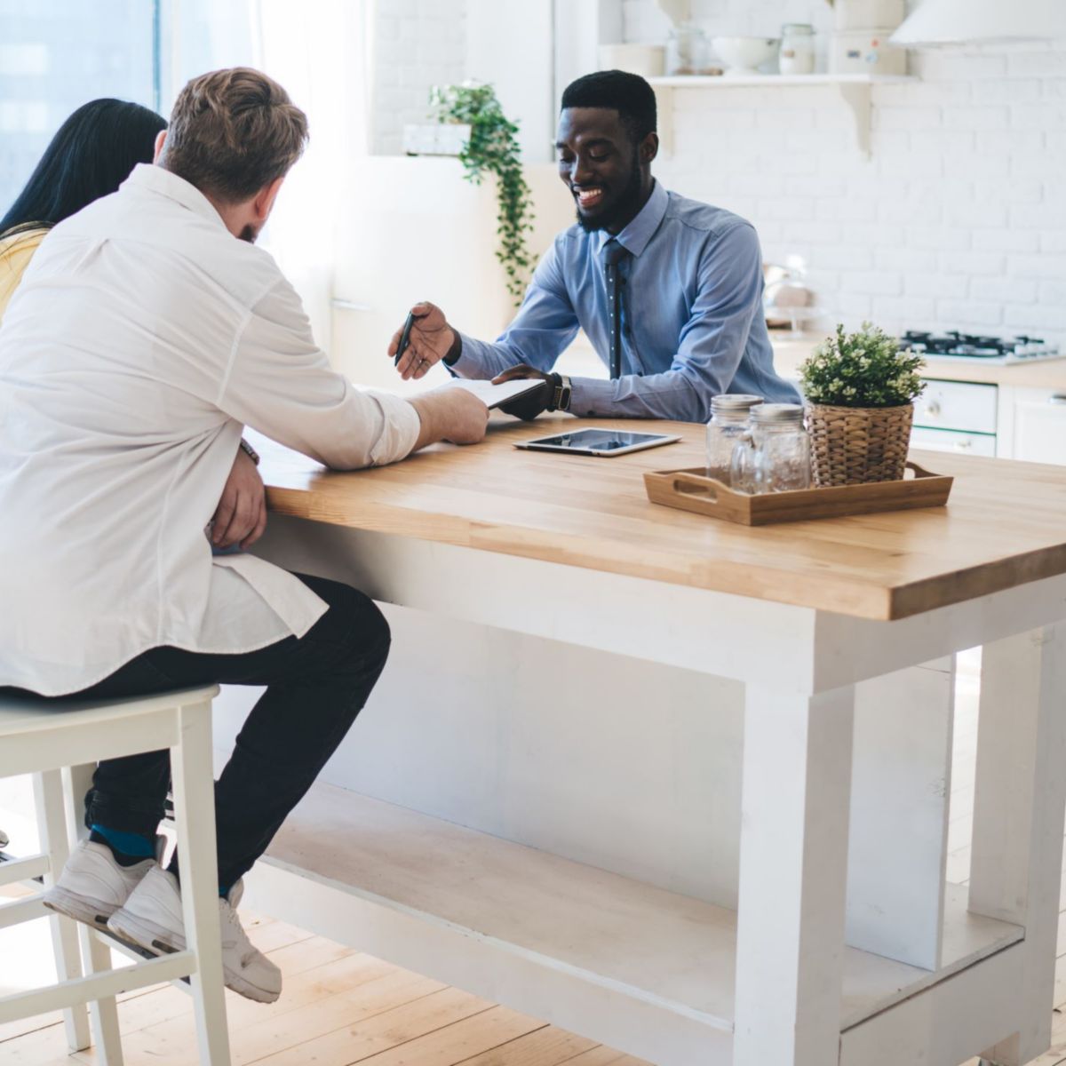 Real Estate Agent Sitting With Couple in Kitchen