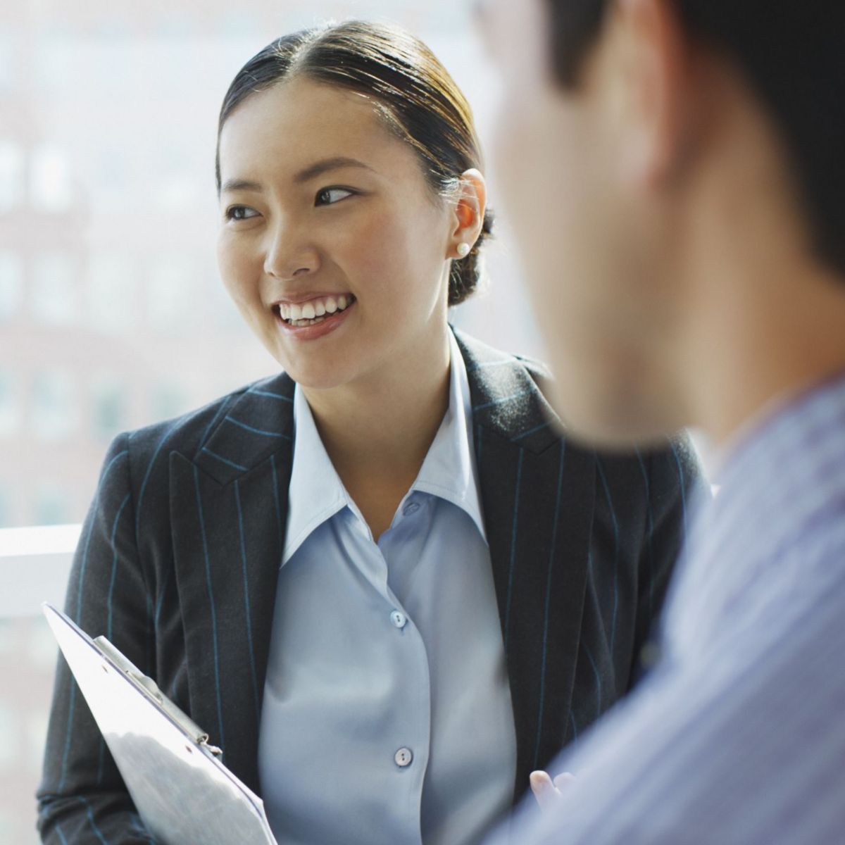 Three professionals in business attire chatting