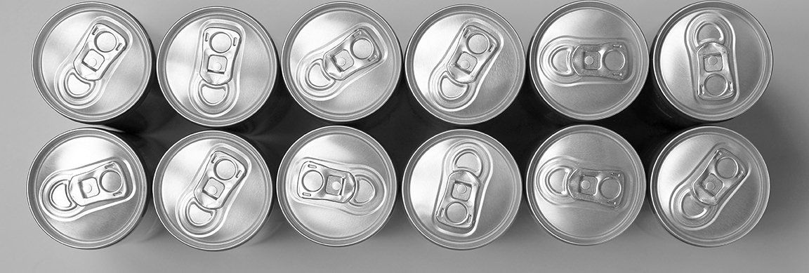 Rows of silver pull-tab lids viewed from above on sealed beverage cans.
