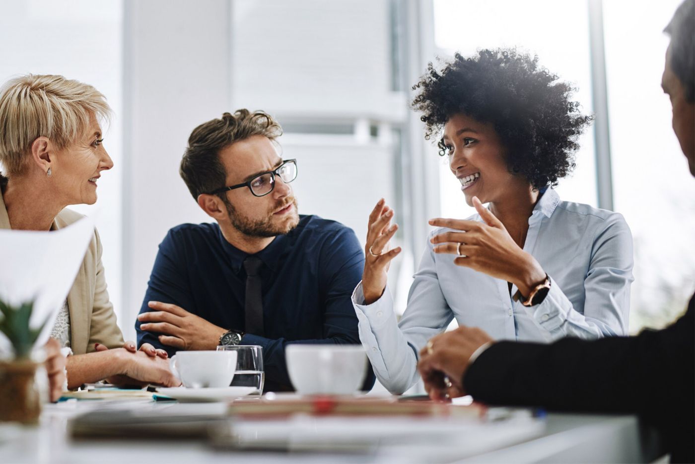 A team engages in discussion during a meeting, sharing ideas and insights at a conference table.
