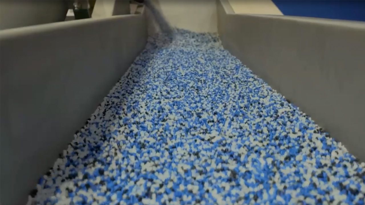 Witness the processing of materials in a state-of-the-art industrial facility. This image captures the efficiency of operations as blue and white materials are transported and prepared for further processing.