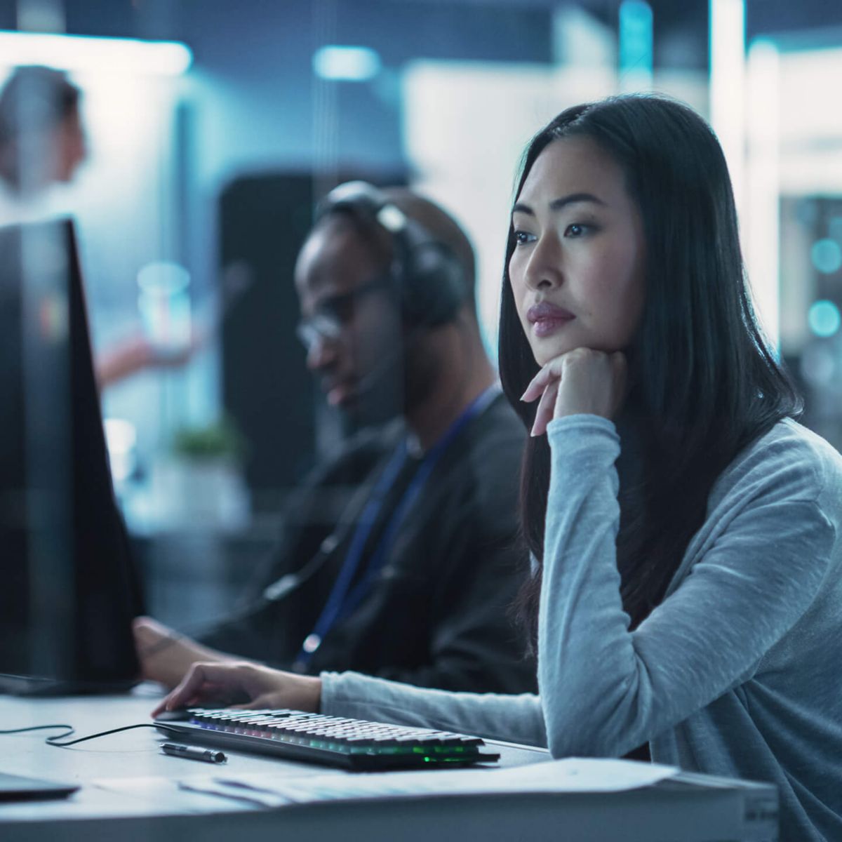 Two workers working at computer monitor.