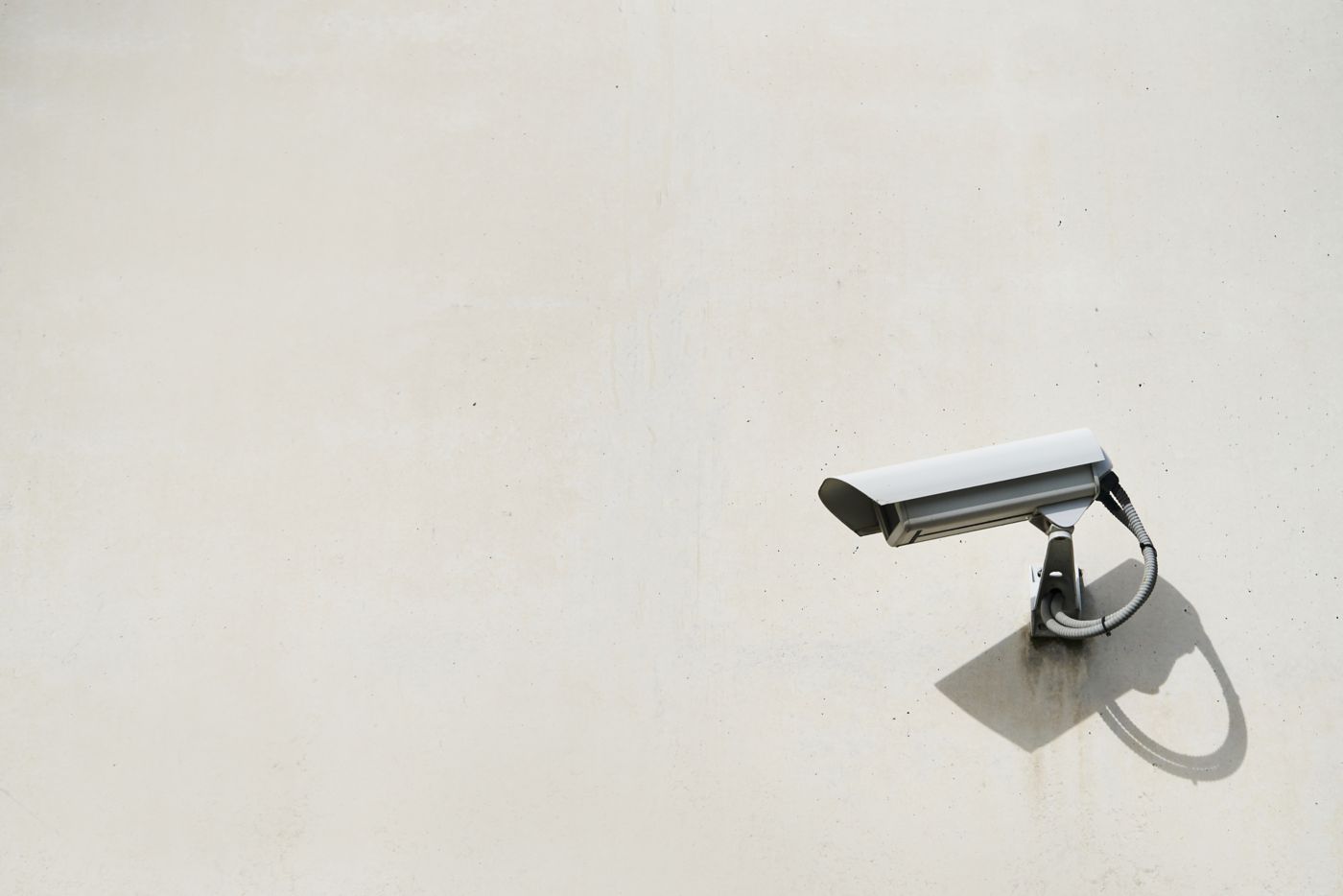 Close-up of a security camera hanging on the exterior wall of the building. Security concept.