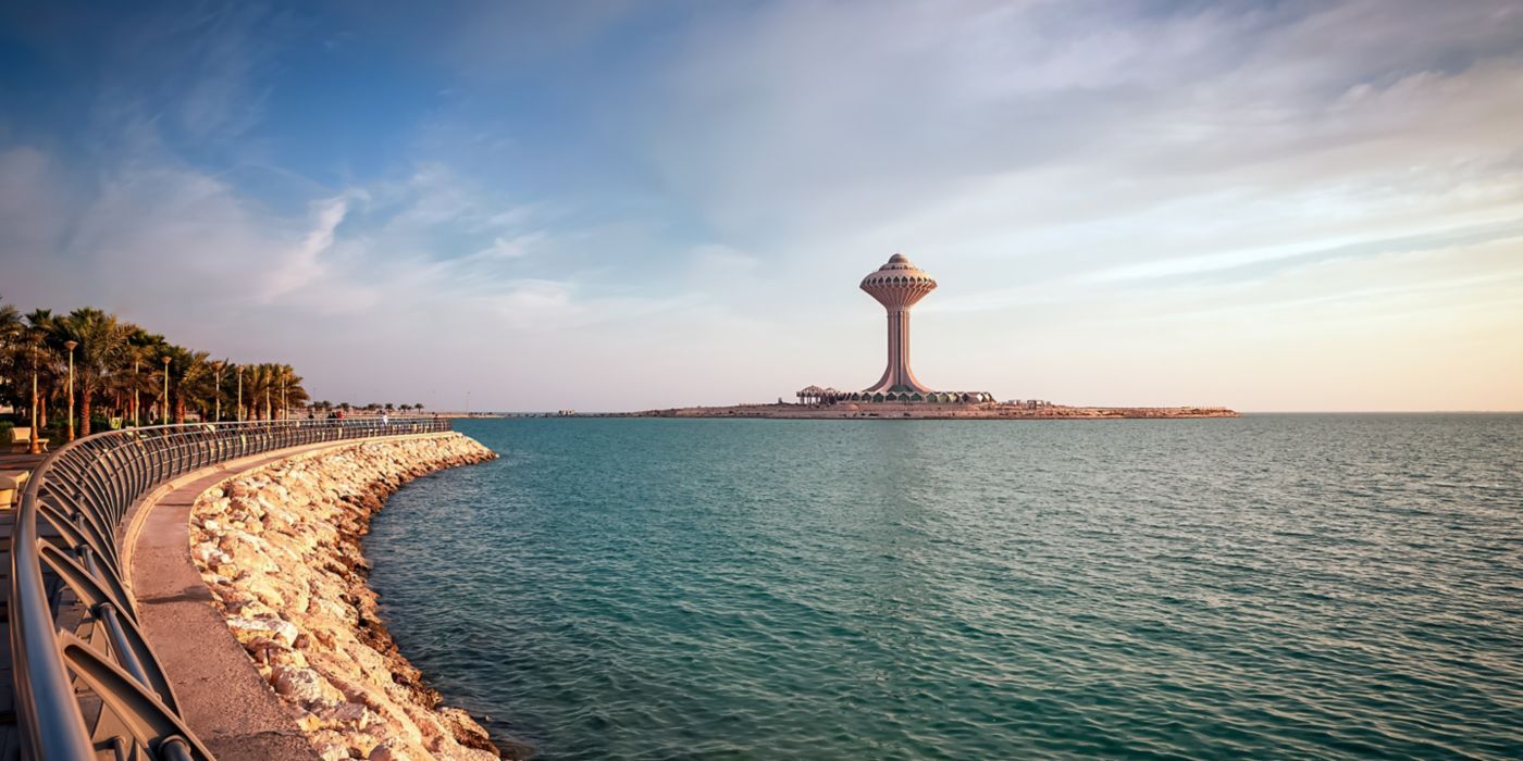 Scenic view of Dammam water tower by the sea with promenade and clear blue sky.