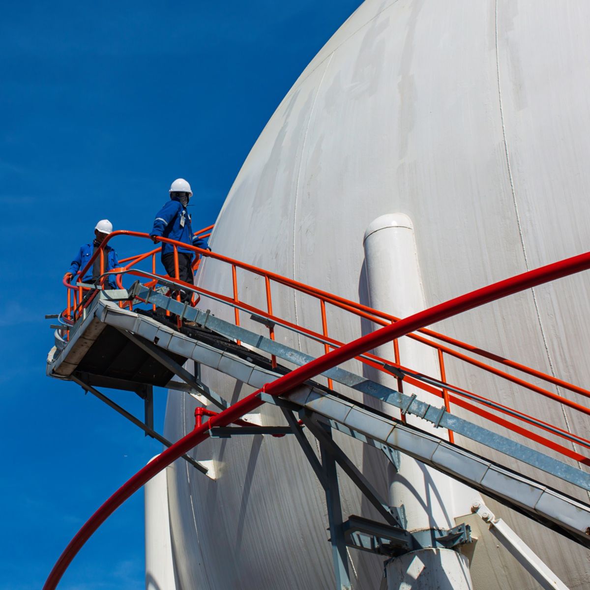 White spherical propane tanks containing fuel gas pipeline and scaffolding work