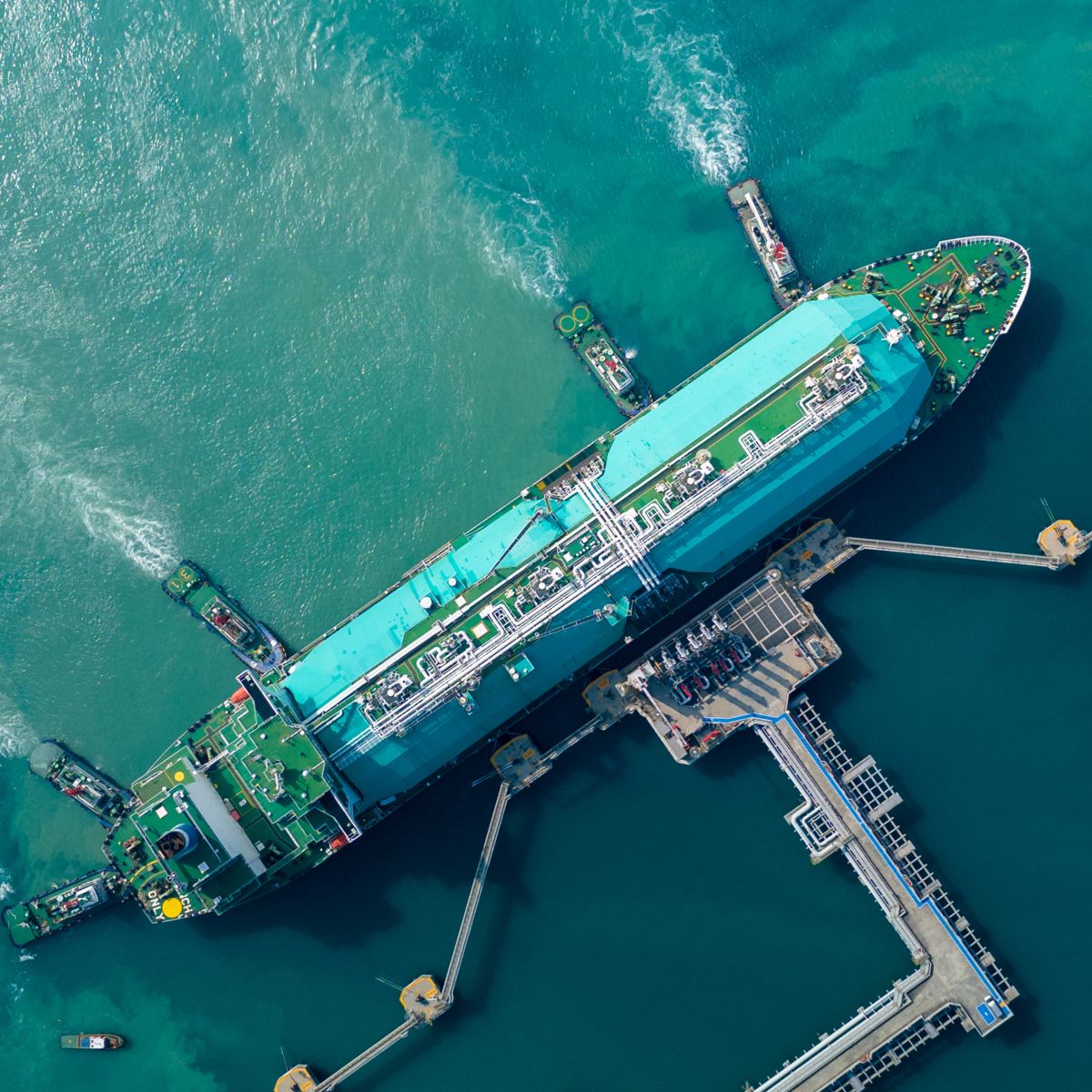 Aerial view of an LNG carrier docked at a marine terminal, showcasing liquefied natural gas logistics, maritime operations, and energy supply chain infrastructure.