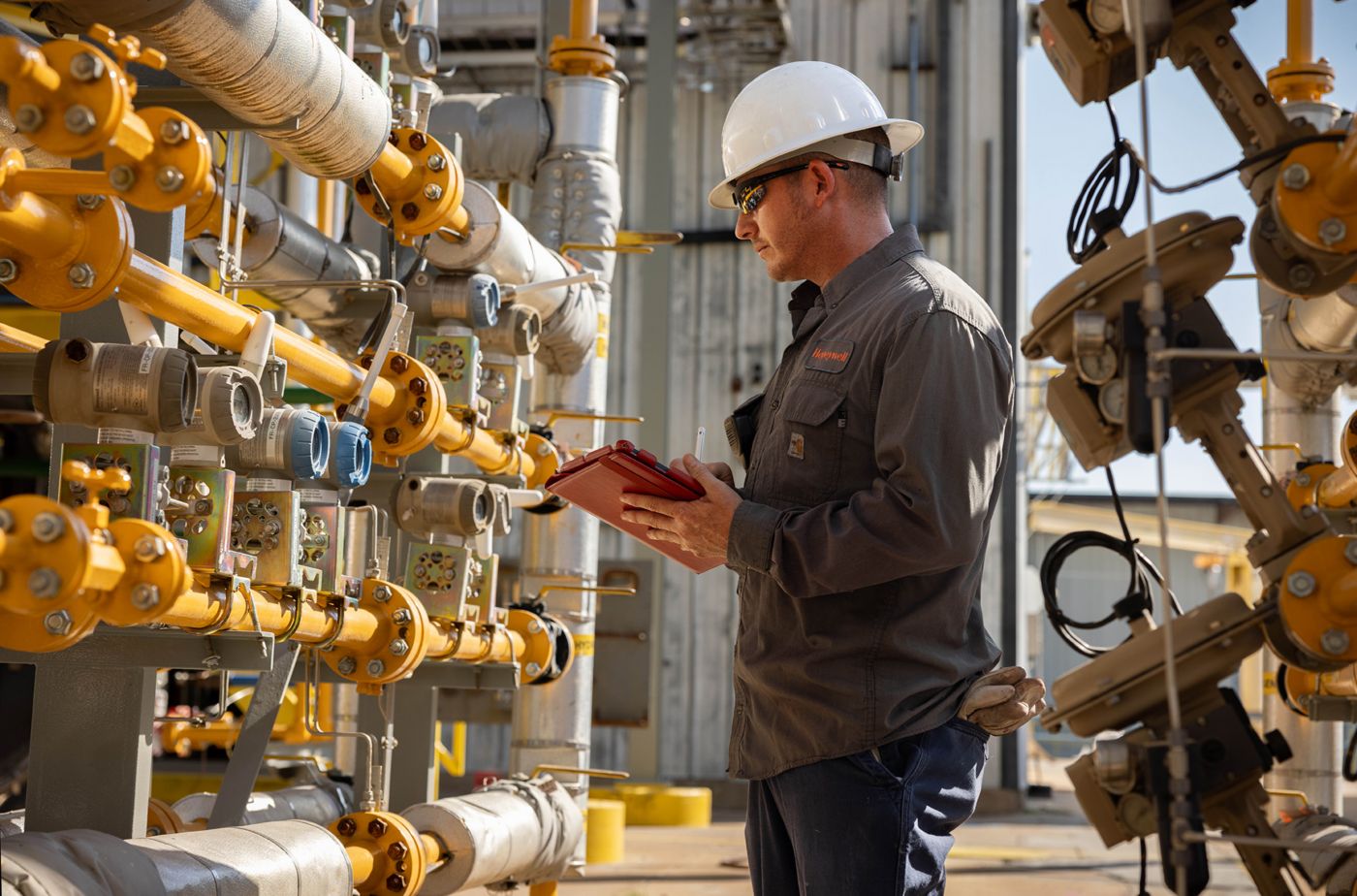 Technician inspecting flow sensors and transmitters on industrial piping, ensuring accurate measurement, system reliability, and optimized process performance.
