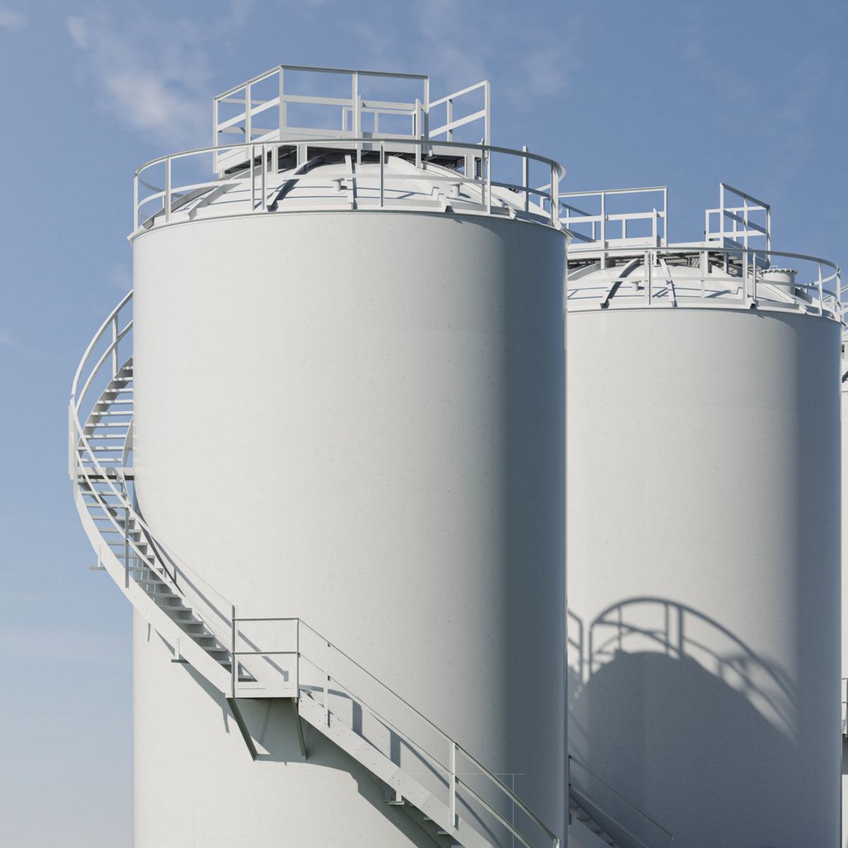 Three identical white industrial silos featuring external spiral staircases against a clear blue sky.