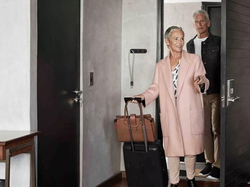 Hotel guests entering a room with modern electronic locking technology, supporting secure access, operational efficiency, and an enhanced hospitality experience.