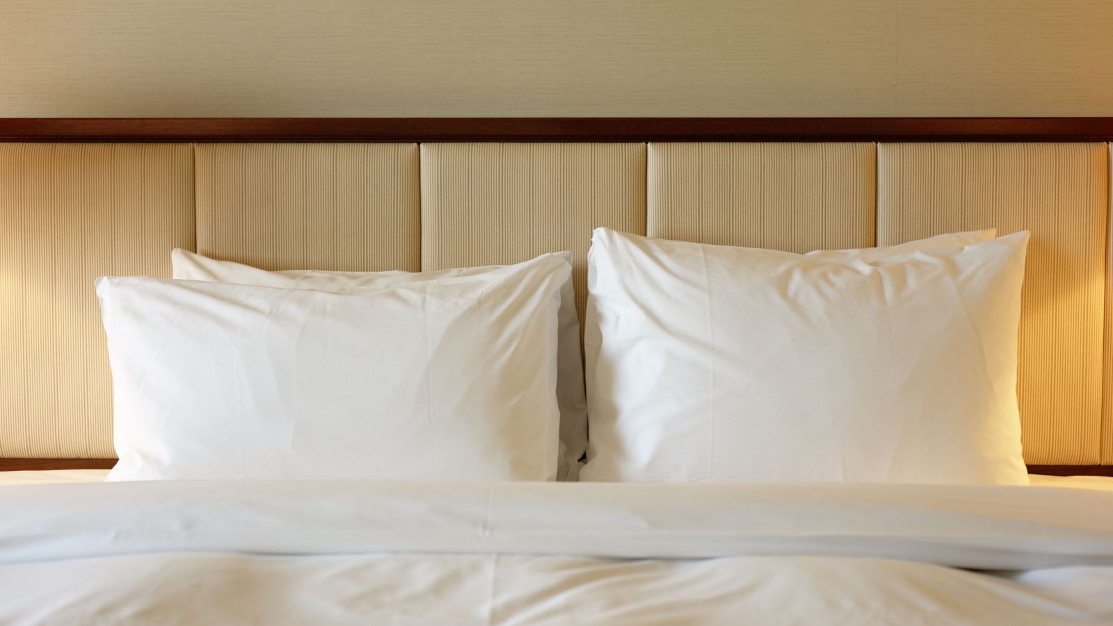 hon-hotel-room-white-pillows-upholstered-headboard-luxury-157683557.jpg