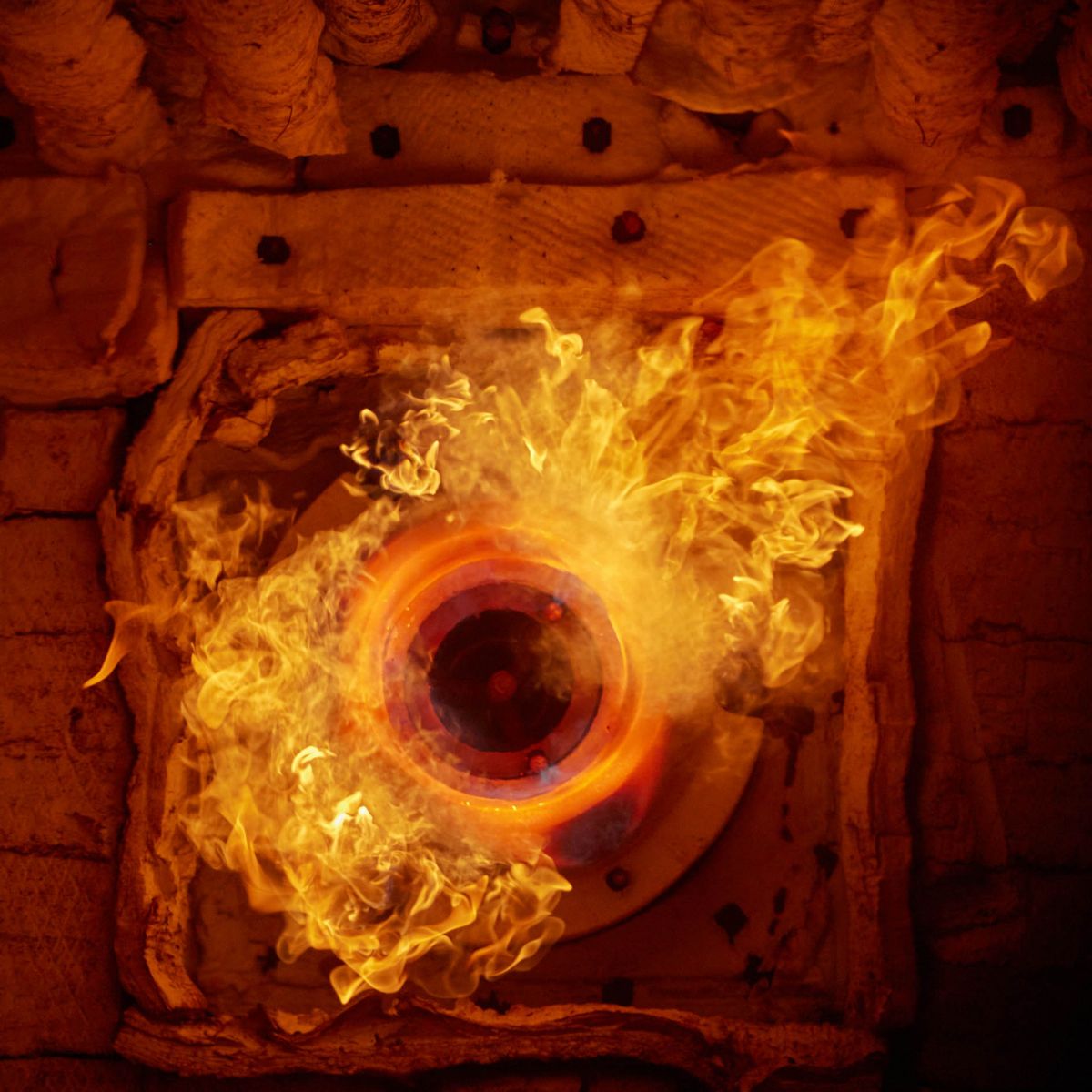 Close-up of an industrial burner generating an intense flame, highlighting controlled combustion, thermal performance, and high-temperature processing applications.
