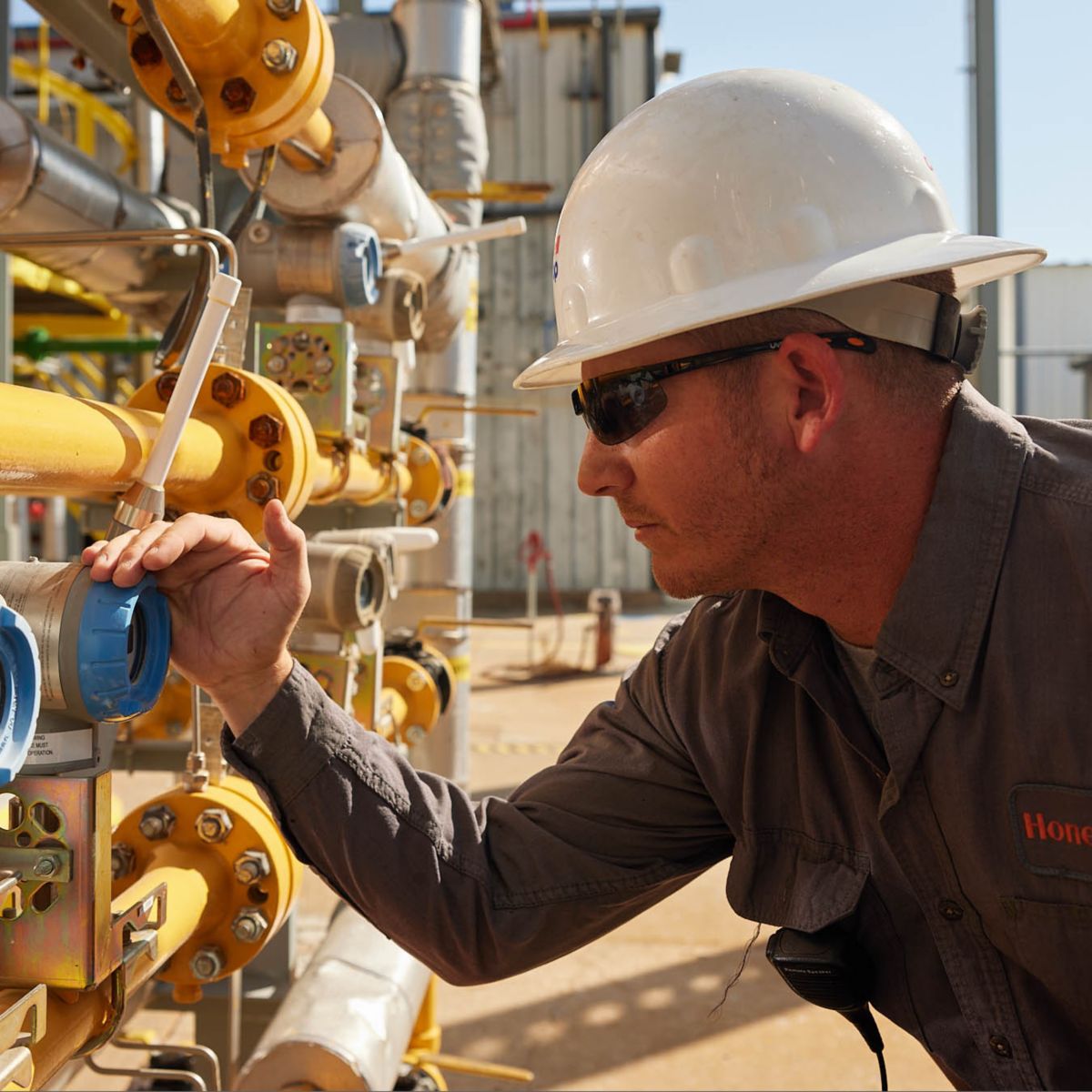 Technician inspecting a flow transmitter on an industrial gas piping system, ensuring accurate measurement, system reliability, and optimized process performance.