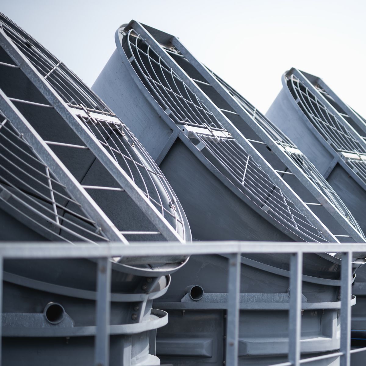 Large industrial ventilation fans installed on a commercial building rooftop, representing modern HVAC systems, energy efficiency, and urban infrastructure.