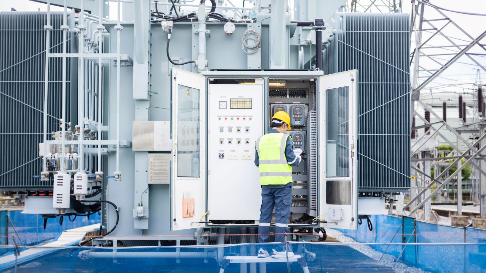 A technician in safety gear inspects control panels at a power station, ensuring optimal operation.