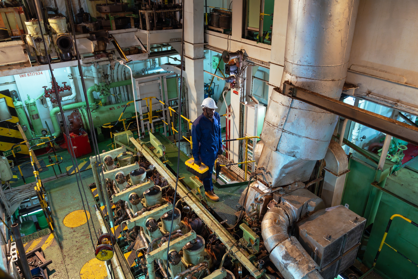Portrait of a ship worker is walking in the ship's engine room