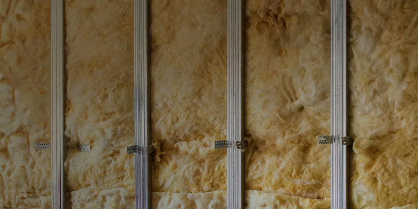 Close-up of fiberglass insulation in wall framing, highlighting thermal efficiency, energy savings, and modern building materials.
