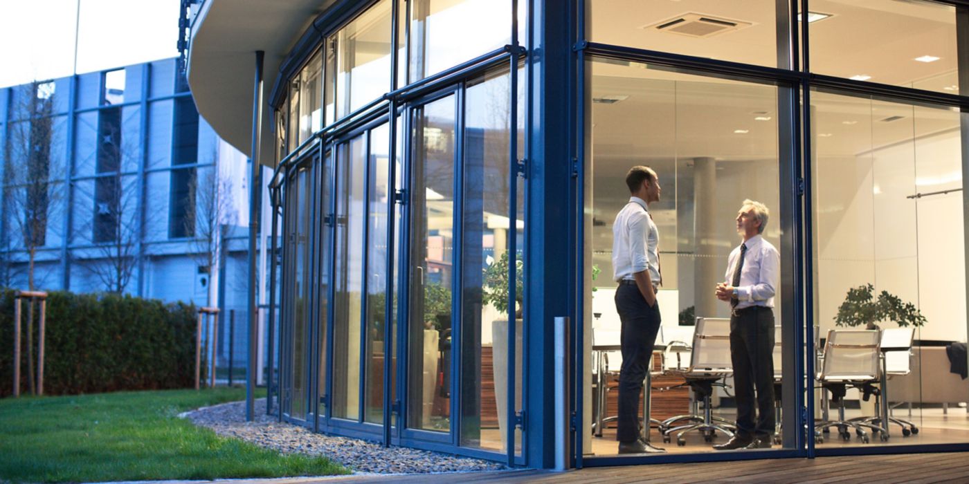 Two Office Colleagues in a Glass Building