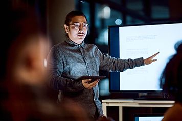 Shot of a young businessman delivering a presentation during a late night meeting at work