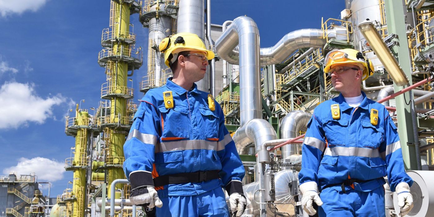 group of industrial workers in a refinery - oil processing equipment and machinery 