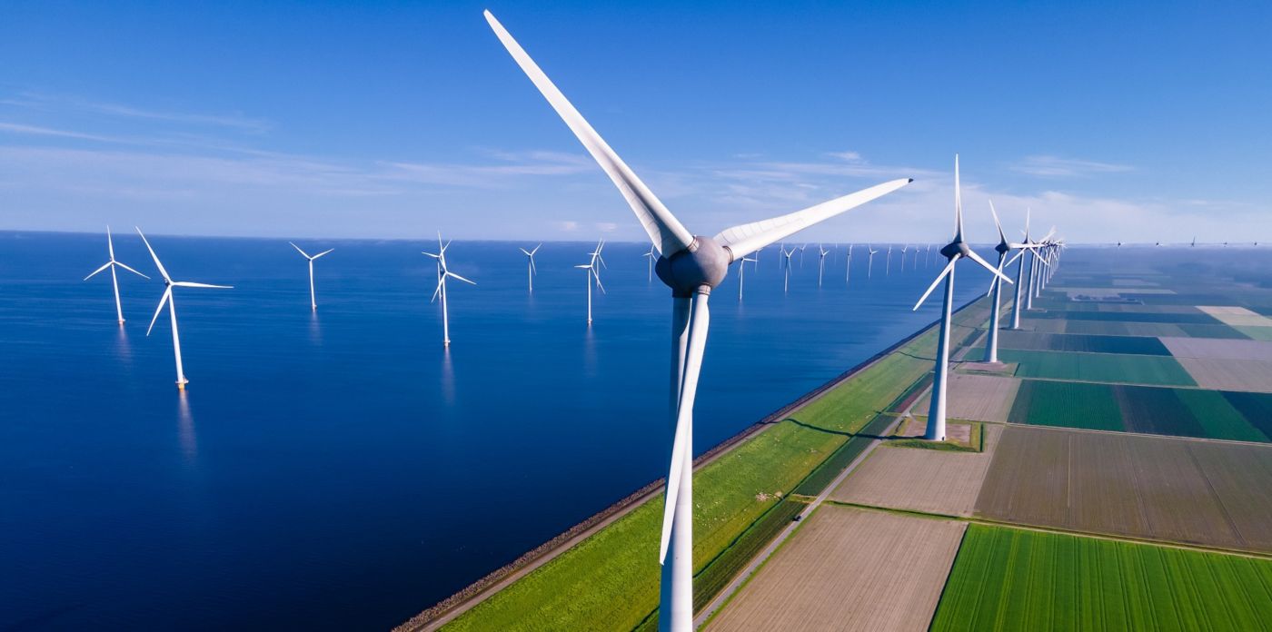 offshore windmill park with clouds and a blue sky, windmill park in the ocean aerial view with wind turbine Flevoland Netherlands Ijsselmeer. Green energy